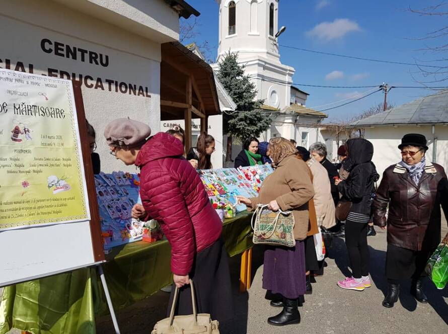 Credincioși alegând mărțișoare la standul din fața Centrului Social-Educațional