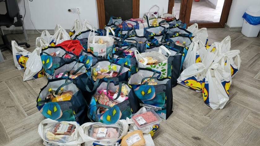 Pachete cu alimente pentru Paști, pregătite în sacoșe pe podea