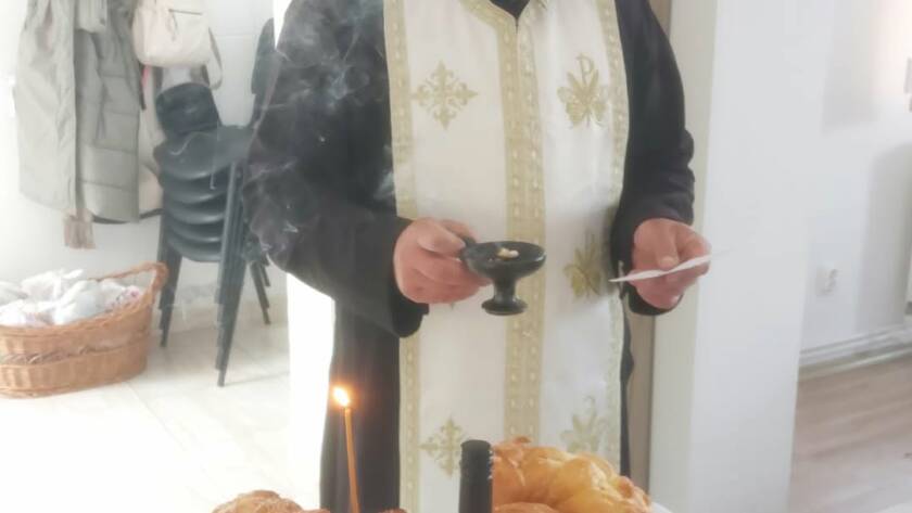 Preot săvârșind slujba Parastasului la cantina socială