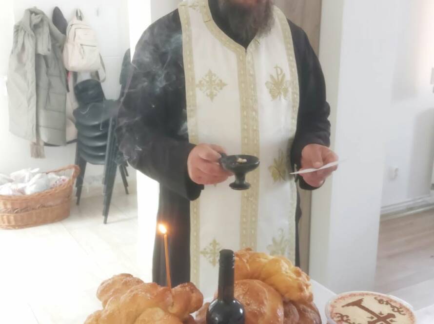 Preot săvârșind slujba Parastasului la cantina socială