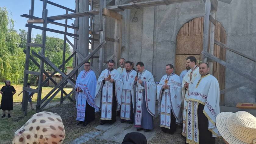 Preoții slujitori, în veșminte, în fața bisericii „Adormirea Maicii Domnului și Sfântul Mucenic Haralambie”