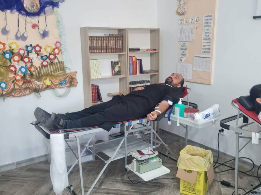 Donator întins pe patul de recoltare în sala Centrului social-educațional al parohiei