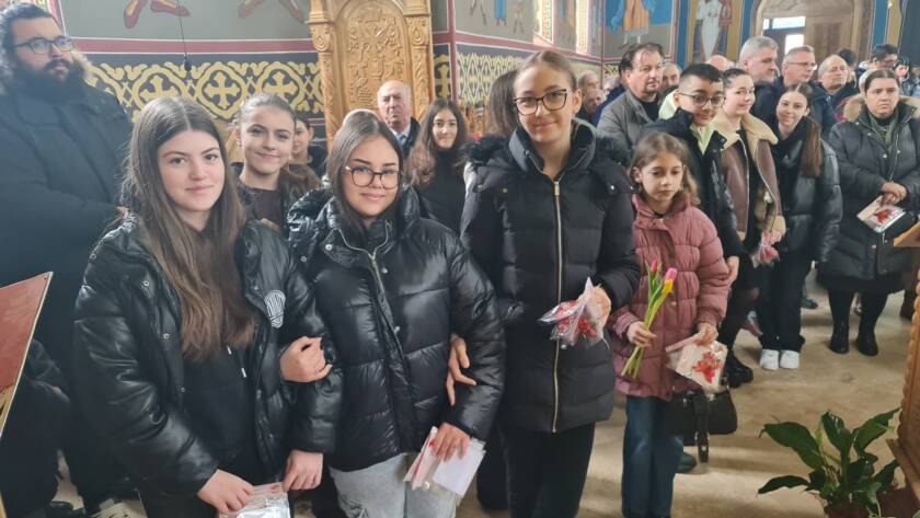 Copiii programului catehetic cu mărțișoare și flori în biserică
