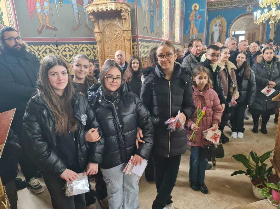 Copiii programului catehetic cu mărțișoare și flori în biserică
