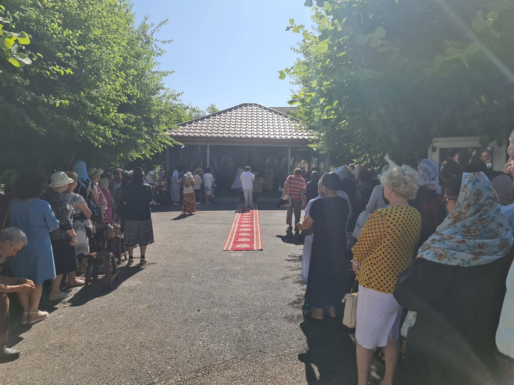 Credincioși adunați în jurul altarului de vară pentru slujba hramului.