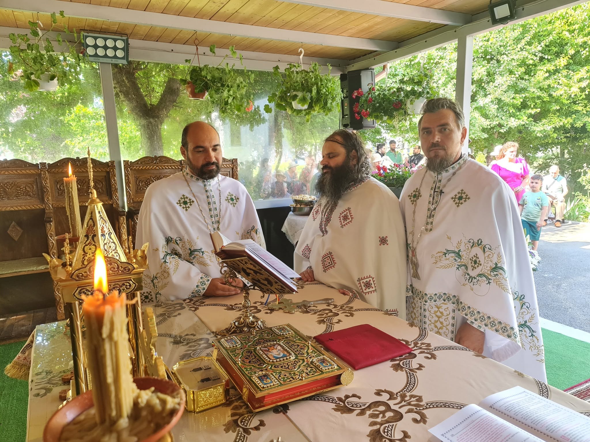 Trei preoți în timpul slujbei oficiate la altarul de vară.
