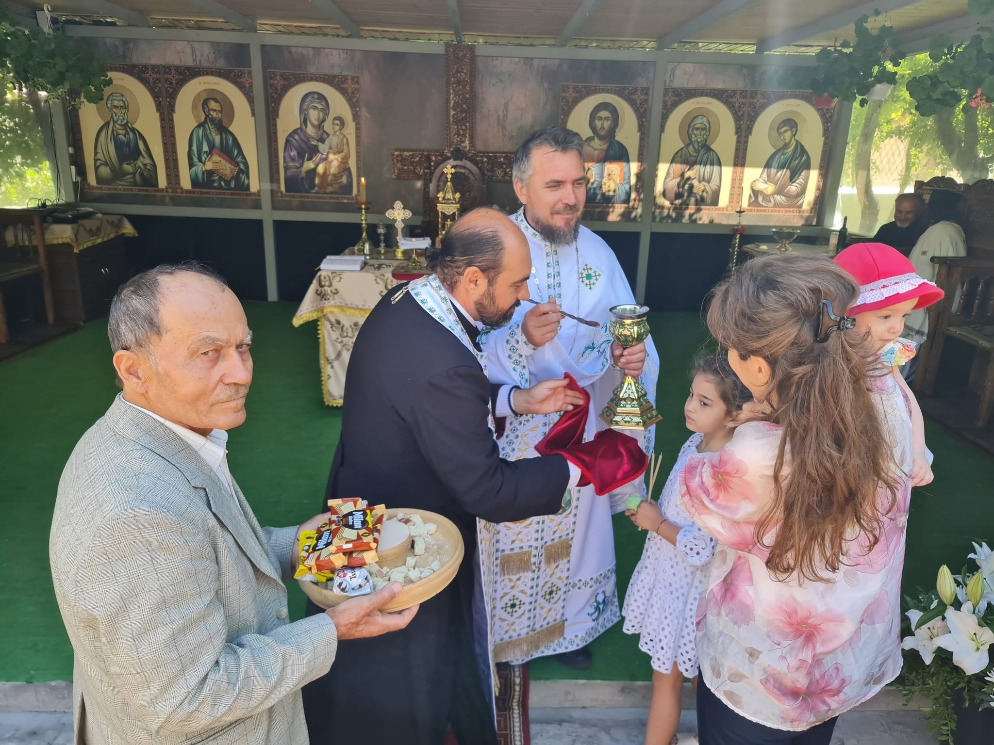Copii și părinți în fața preoților, după slujba hramului.