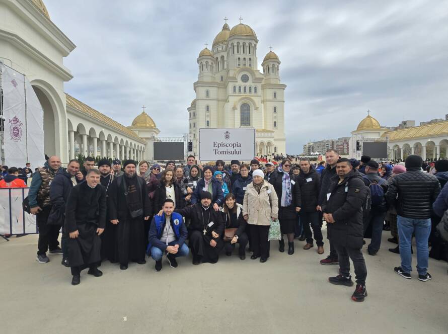 Fotografie de grup a pelerinilor din delegație, cu pancarta „Episcopia Tomisului”, în fața Catedralei Naționale
