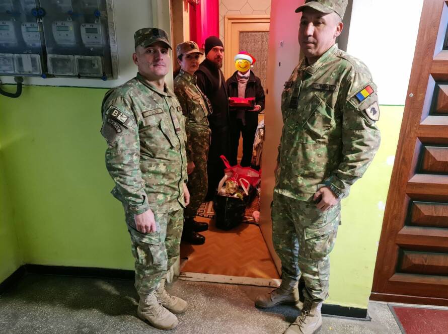 Militari, un preot și o beneficiară în jurul darurilor aduse în locuință