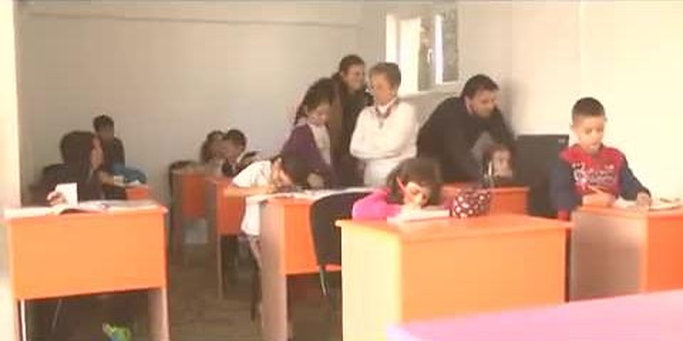 Copii lucrând la teme în sala parohiei, la reluarea proiectului în 2015 (cadru din reportaj)